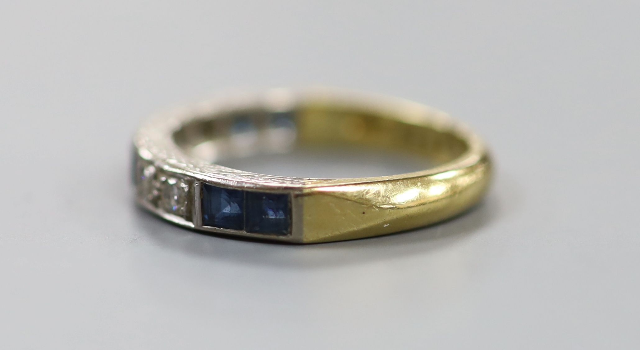 A modern 18ct gold and channel set six stone sapphire and four stone diamond half hoop ring, size O, gross 4.8 grams.